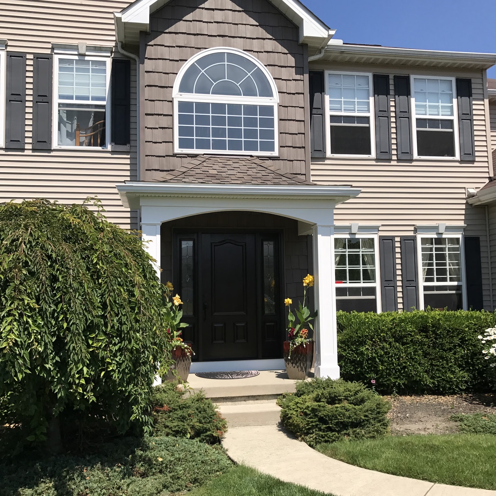Home with an arched entryway, brick and siding