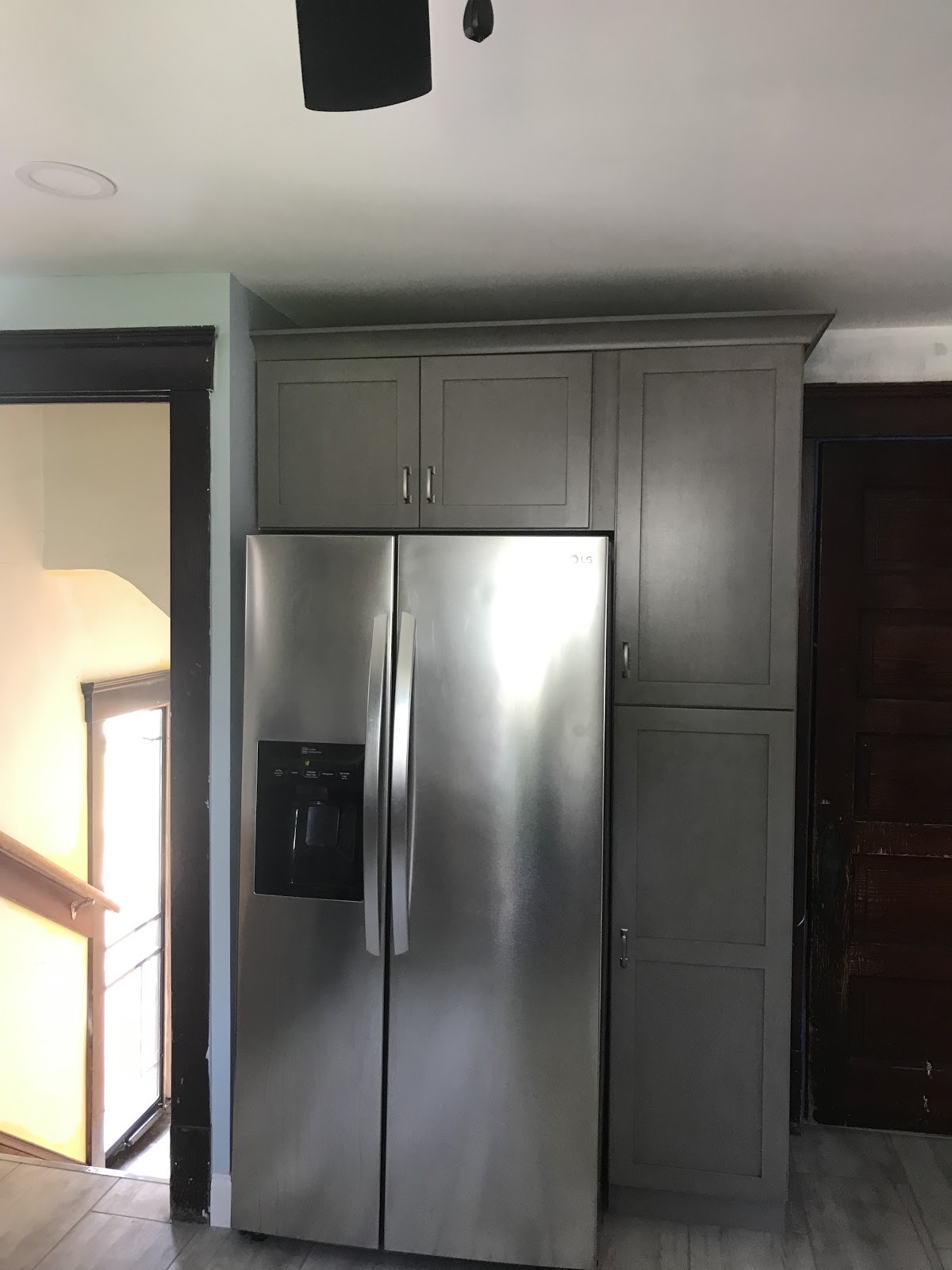 Remodeled kitchen with grey cabinets and stainless appliances