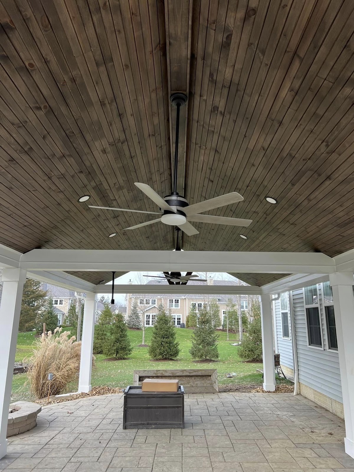 Covered porch addition with a wood-plank ceiling and ceiling fan