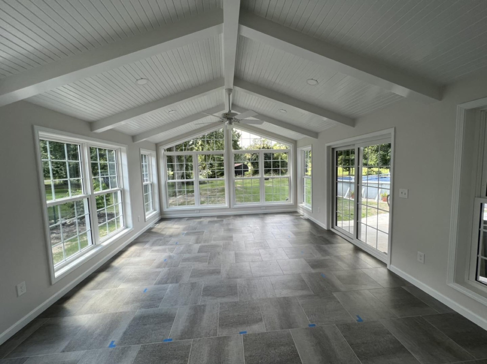 Enclosed sunroom addition with a wall of windows and wood floor